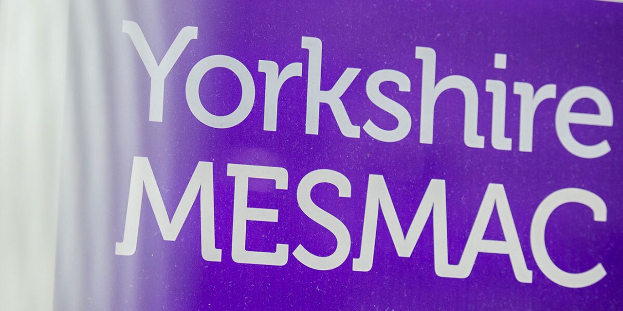 Close-up of a purple Yorkshire MESMAC sign with the logo in white.