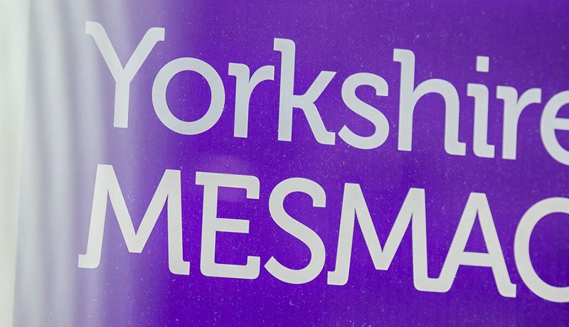 Close-up of a purple Yorkshire MESMAC sign with the logo in white.