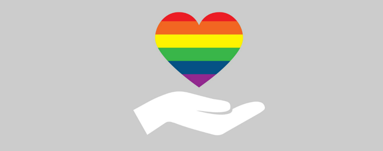 Illustration of a hand holding a rainbow-striped heart on a grey background.