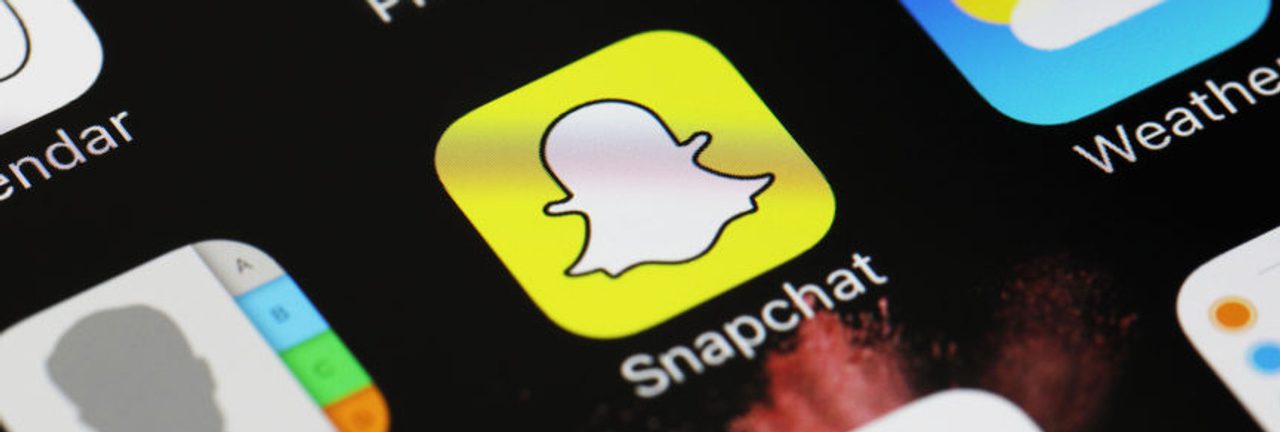 Close-up of a phone screen showing the Snapchat app icon among other apps.